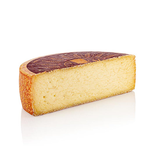 A photo of a 21 kg organic half hard cheese, Urgestein Reserve, with a half loaf of bread